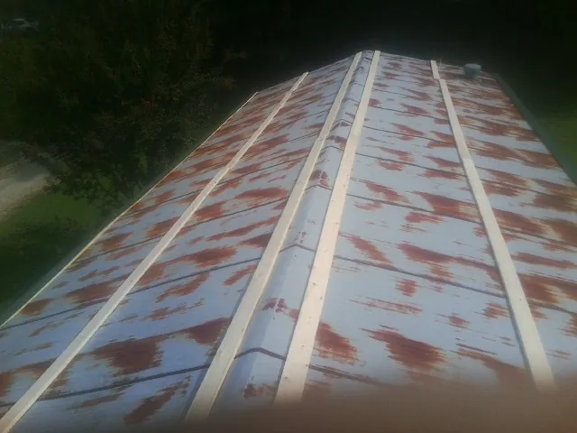 Rusted metal roof panels with new wood purlins before replacement — Storm Damage Roof Repair in Ackworth by Roofing Brothers