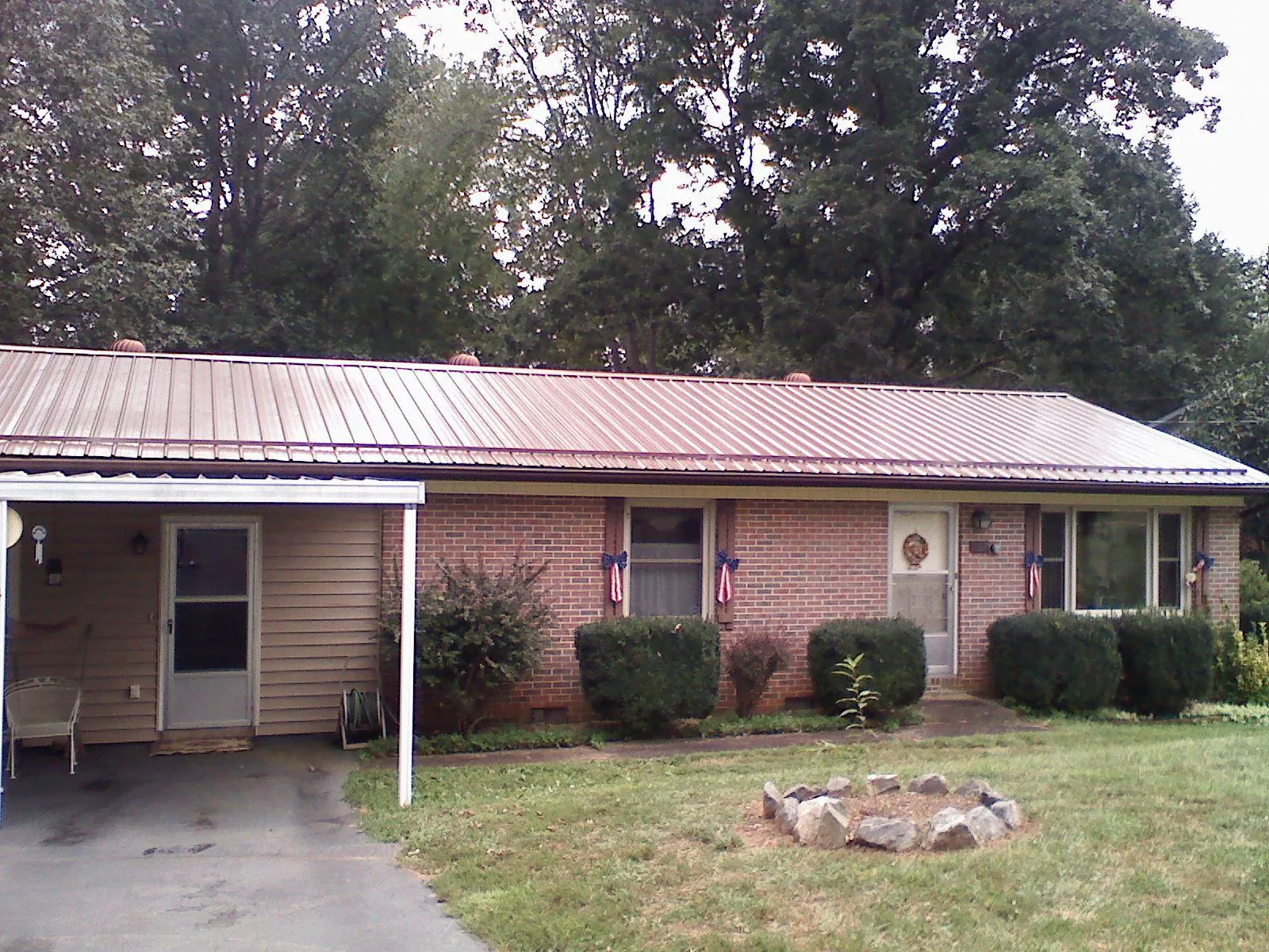 Bronze metal roof and carport on a brick ranch home — Roof Repair work by our crew in Ackworth